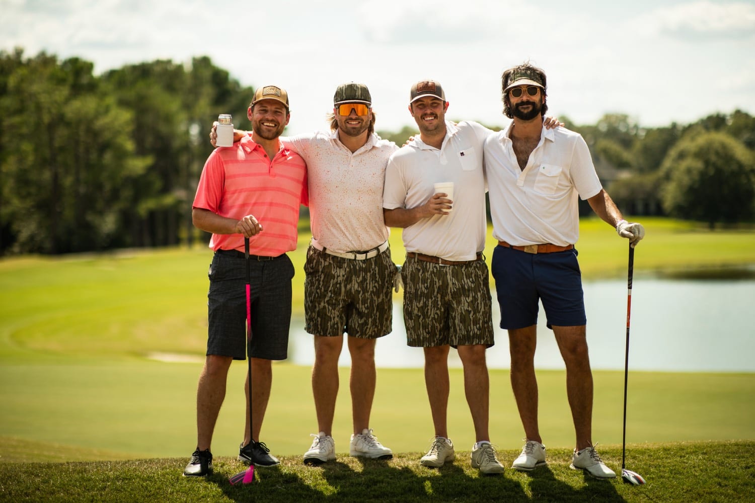 four golfers pose with camo shorts